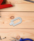 Three-Piece Dent Puller Ring Kit for Auto Body and Sheet Metal Repair, Aluminum Construction With Seamless Finish displayed on wood