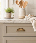 Three Pack Antique Brass Half Moon Cup Pulls For Kitchen Cabinets And Drawers Featuring Hella Smooth Finishes And Rock Solid Zinc Alloy Build With Detailed Cuts That Bring Fresh Charm To Furniture And Vanity Projects Quick And Easy mounted on a light gray cabinet.