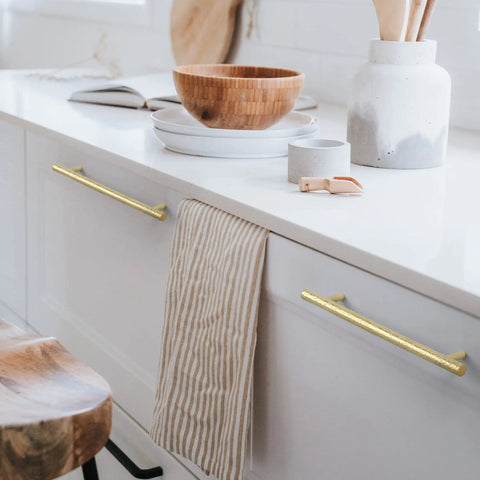 Top Shelf Six Pack Solid Brass T Bar Cabinet Pulls Hella Durable Gold Hardware For Kitchens And Dressers Clean Hammered Polish With Five Inch Center Spacing on white cabinets.
