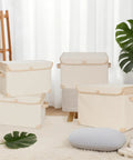 Kick Some Clutter To The Curb With These Roomy Foldable Storage Bins Featuring Tough Reinforced Side Panels And Snug Fitting Covers. Set of beige collapsible bins in a living room setting.
