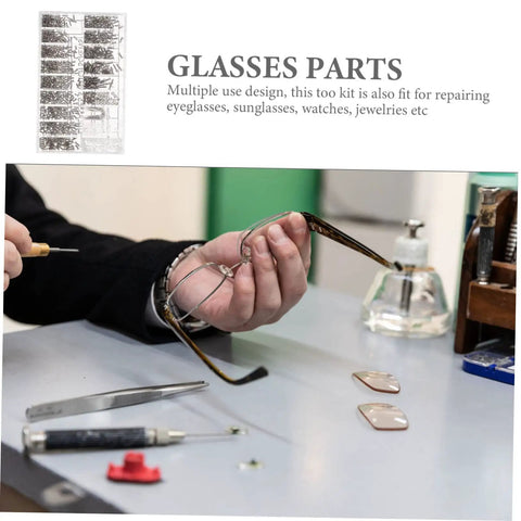 Person holding eyeglass frame with Assorted Eyeglass Repair Screws Kit For Sunglasses And Watches on desk, tools visible.