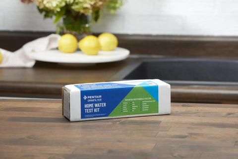 Convenient OMNIFilter Mail Home Water Test Kit on countertop, ready for analysis, ensuring top shelf drinking water quality daily.