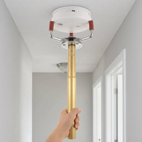 Pro Grade Smoke Sensor Extraction Tool Featuring A Rock Solid Aluminum Claw Grip designed for quick detach jobs being used on a smoke detector.