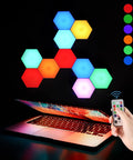 Hexagon LED Wall Panels 10 Pack With Remote And Touch Control RGB 13 Color Lights arranged above open laptop with hand holding remote