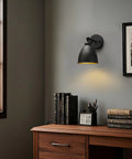 Industrial Hardwire Wall Sconce With Old School Farmhouse Vibe installed above desk, black finish, right-angled metal lampshade