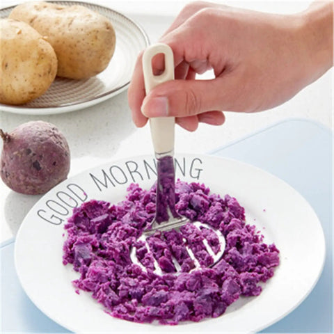 Using Top Rated Stainless Steel Potato Ricer And Masher Set with sturdy handles to mash purple potatoes on a plate.