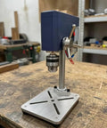 Compact Mini Bench Drill Press And Grinding Power Tool For Hobbyists with stable metal base, side view on workbench.