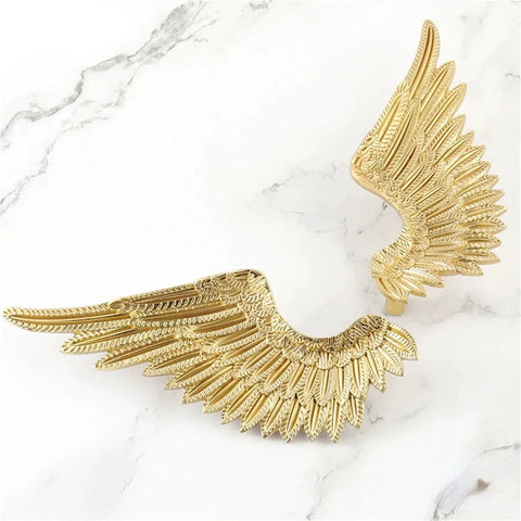 Heavy Duty Solid Brass Wardrobe Handles Featuring Slick Matte Gold Angel Wing Design and Badass Cabinet Knobs, close-up view.
