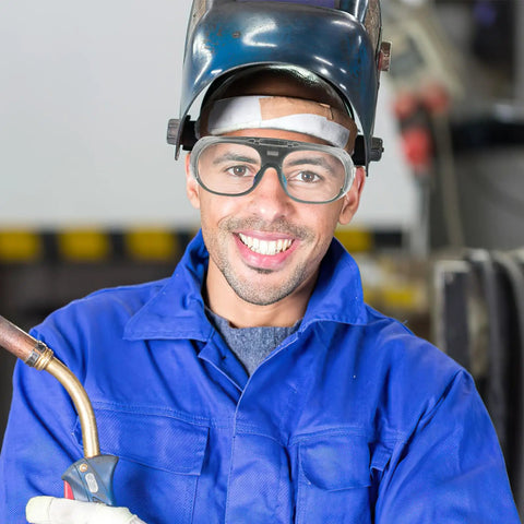 Man wearing Heavy Duty Pair Of Welding Goggles With Double Layer Plastic Lens while holding welding torch in workshop.