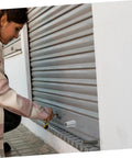 Person using Badass Hurricane Shutter Hardware Plus Window Shutter Stopper Kit to adjust a roller shutter.