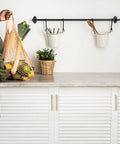 Top Shelf Champagne Gold Square Cabinet Handles For Modern Kitchen Drawers Hella Strong Heavy Duty Metal Construction With Ultra Smooth Finish And Quick Install 4 Inch Spread with green vegetables in a net bag.