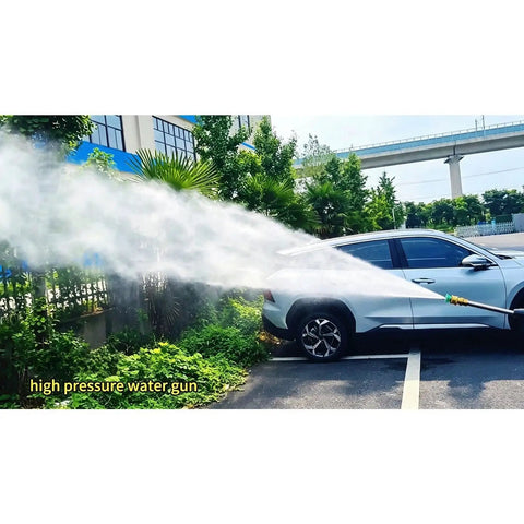 High pressure water gun spraying water on a parked car surrounded by greenery, showcasing powerful cleaning capability.
