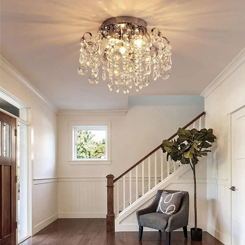 Small Crystal Chandelier Flush Mount Ceiling Light Three Light Modern Sleek Chrome Iron Raindrop Fixture illuminating an entryway.