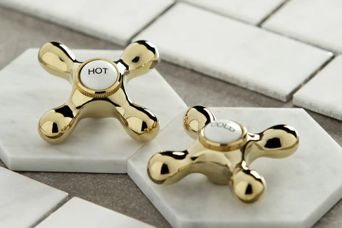 Heritage Wall Mount Bathroom Faucet Polished Brass Hot and Cold Knobs on marble tiles.