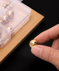 Person holding a solid brass bearing ball from the Built Tough Solid Brass Bearing Balls Assortment 160 Piece storage kit.