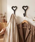 12 Pack Heavy Duty Cast Iron Coat Hooks Wall Mounted Black Workhorse Wall Storage For Coats Bags Built Tough For The Daily Grind With A Sleek Flat Black Finish That Lasts In Any Room, showcasing two hooks with a shirt and jacket.