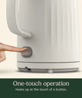 Close-up of finger pressing button on Soho 1-Liter Double Wall Electric Kettle With Stainless Steel Interior One-Touch Boil For Tea.