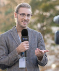 Man using Super Smooth Grip Handheld Adapter For Wireless Lavalier Mics In A Solid Twin Pack Setup Compatible With Dji Rode And Hollyland Gear.
