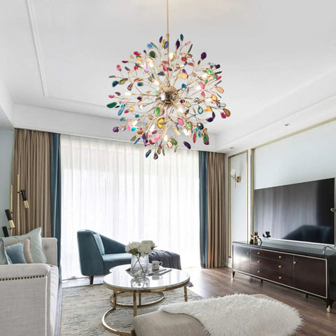 Modern living room with colorful chandelier, white sofa, and round glass coffee table.
