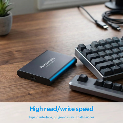 Beefy 4TB Portable SSD USB-C External Solid State Drive Metal Build next to keyboard on wooden desk