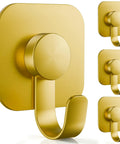 Heavy Duty Adhesive Wall Hooks In A Dope Four Pack, Stainless Steel Stick On Hangers With Badass Grip For Bathrooms And Kitchens, Waterproof And Super Fast To Put Up On Any Wall Or Door Without Drilling, Classic Gold Finish, close-up of one hook.