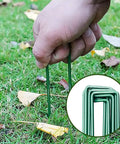 Heavy Duty Garden Stakes And Ground Anchors Set 10 Pack Galvanized U Hooks being inserted into lawn for landscape weed barrier securing