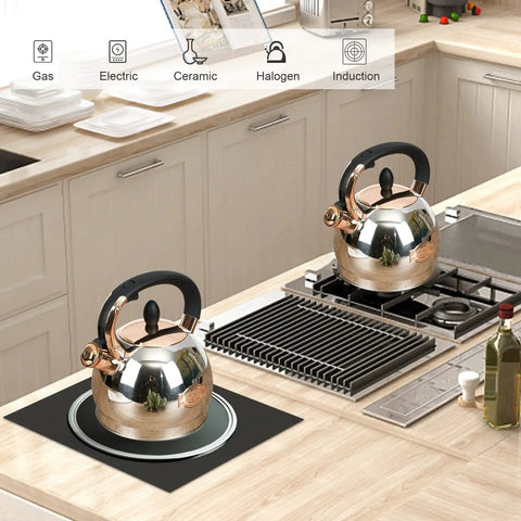 Two stainless steel whistling tea kettles on a kitchen stove, 2.8 quart, encapsulated bottom for even heat distribution, compatible with various stove types.