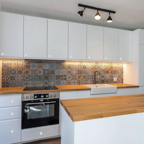 Slick Vintage Floral Ceramic Cabinet Knobs In Rich Red on white cabinetry with a wooden countertop and patterned backsplash.