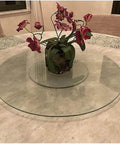 Round Lazy Susan Turntable With Smooth Aluminum Bearings And Heavy Duty Tempered Glass Swivel Serving Tray For House Parties Family Dinners And Holiday Feasts Easy Breezy Cleanup 34 Inch on a dining table with flowers.