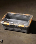 Toss Your Gear In This Heavy Duty 5.28 Gallon Waterproof Plastic Storage Tote Bin with orange latches on a concrete floor.