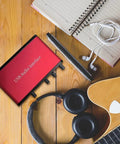 2x2 USB Audio Interface With 48V Phantom Power And 24-Bit 96kHz Recording next to headphones, notebook, smartphone, and guitar