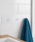 5Pc Heavy Duty Wall Mounted Storage Rack Featuring Hardcore Adhesive Hooks For Bathroom And Shower Caddy No Sweat Rent Friendly Plastic Shelf Rack Quick Grip Design holding a blue towel.