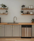 Modern kitchen featuring Thirty Hella Sturdy Brushed Brass Cabinet Knobs on gray cabinets with wood countertop and stainless steel appliances.