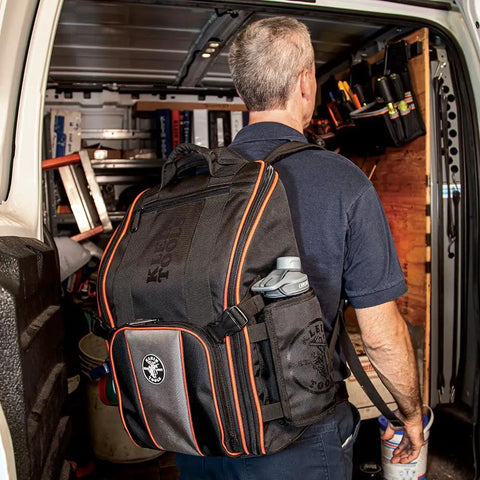 Man wearing Heavy Duty Jobsite Ready Workhorse Tool Backpack With 21 Pockets And Large Interior Water Resistant 1680D Ballistic Weave Backpack