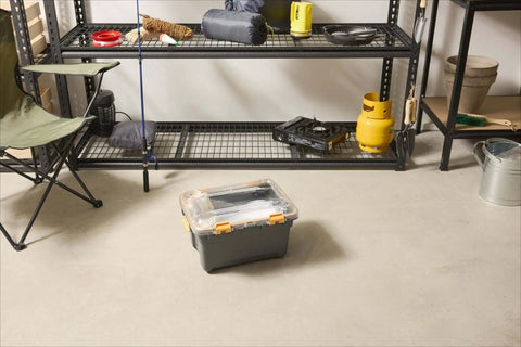 Heavy Duty IP68 Waterproof Plastic Storage Tote Featuring Tough As Nails Gasket Seal And Secure Latches Rugged Gray Bin on a floor beside storage shelves.