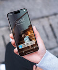 Smartphone displaying notification screen with child on stairs, held in a hand, blurred background visible.