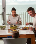 Family enjoying a meal with salad and steak, showcasing the Game Changing Glass Olive Oil Sprayer For Cooking, 16 Oz.