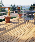Wooden deck with chairs and potted plants showcasing the use of Polymer Coated Size 8 Deck Screw With Coarse Threads And Bugle Head Gray.
