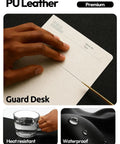 Boss Level PU Leather Desk Protector With Non Slip Grip And Waterproof Surface Sweet Wrist Rest For Smooth Mouse Slide And Kickass Desk Coverage At Home Or Office with hand on a notebook.
