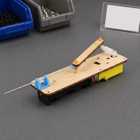 Knockout Classroom Demo Machine Featuring Slick Electric Reciprocating Linkage Model showing mechanical linkage on wood base.