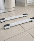 Four Piece Heavy Duty Appliance Gliders Featuring Locking Safety Brakes And Fully Adjustable Height Rollers on tiled floor.
