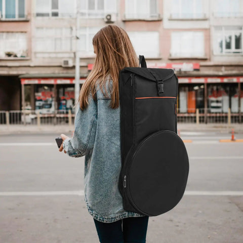 Heavy Duty Black Drum Bag Made For Open Road Rhythms features tough Oxford fabric, worn on a person's back in urban setting.