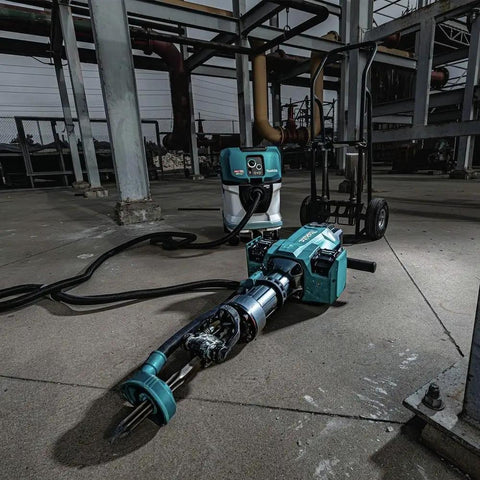 Badass Heavy Duty Eighty Volt Brushless Cordless Breaker Hammer with accessories on a concrete floor in a construction site.