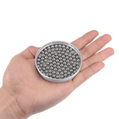 Pro-Gear 6MM 316L Stainless Steel G100 Precision Bearing Balls 100 Count in a hand for easy handling and measurement.