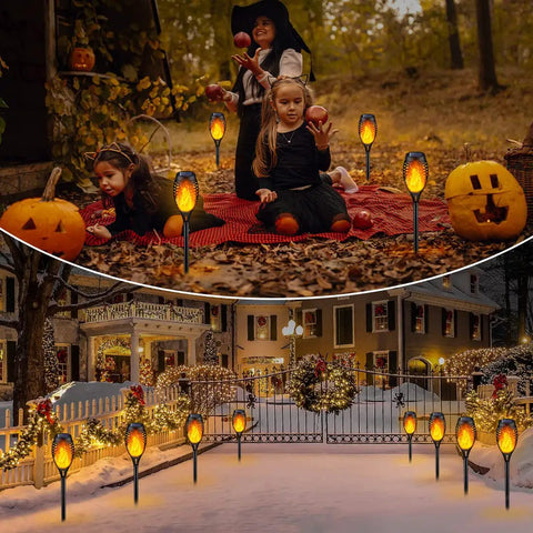 Solar Flame Torch Lights 12 Pack creating flickering flame ambience in garden during festive outdoor Halloween and winter decorations.