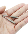 Hand holding two 8 Piece Diamond Chainsaw Sharpener Bits Three Sixteenth Inch Grinding Bits For Chainsaw Chains Stone Burr File Sharpening Kit