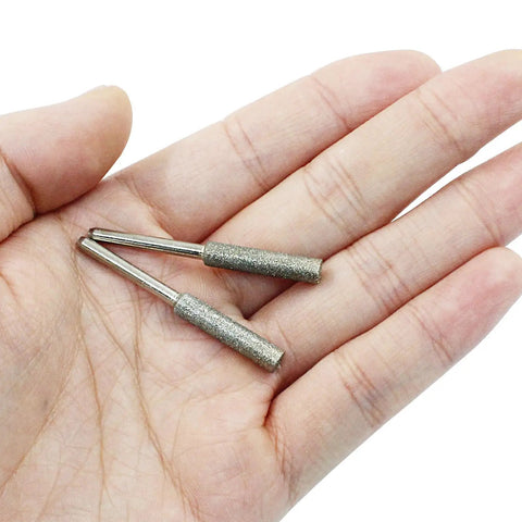 Hand holding two 8 Piece Diamond Chainsaw Sharpener Bits Three Sixteenth Inch Grinding Bits For Chainsaw Chains Stone Burr File Sharpening Kit