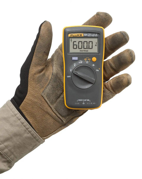 Gloved hand holding Compact Digital Multimeter With 0.5 Percent DC Accuracy, CAT III 600 V Safety, Diode And Continuity Test