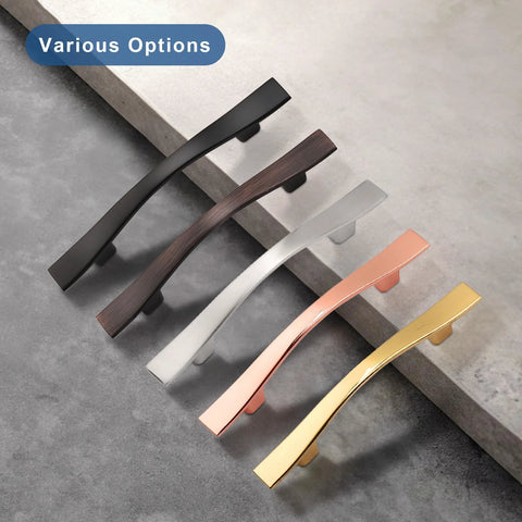 Various options of cabinet handles in different finishes, including black, bronze, silver, copper, and gold, displayed on a counter.