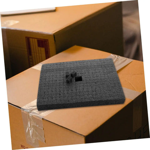 Black Foam Cube Inserts Shockproof Shipping Filler No Sweat Packing Tough As Nails atop a cardboard box.